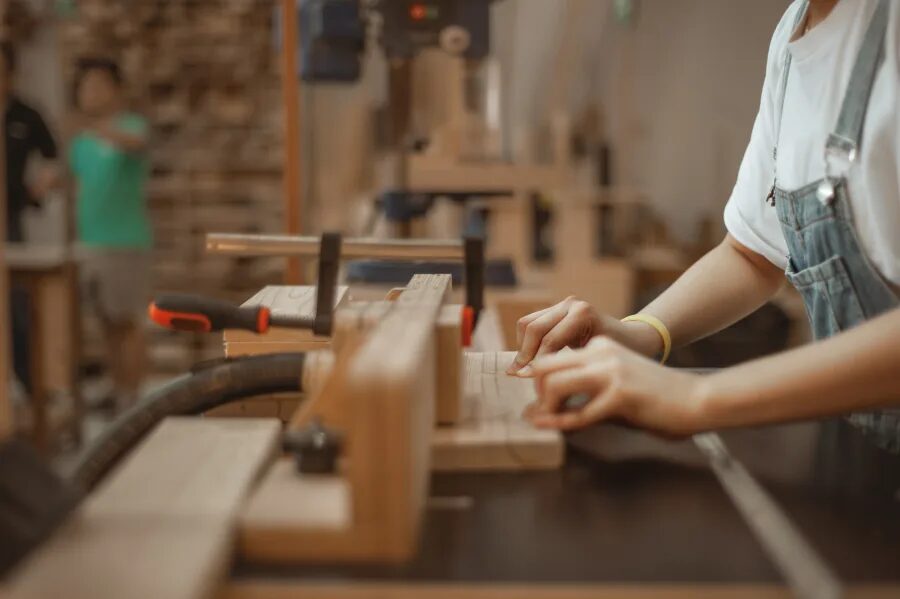 Teenagers and adults working with power tools in the KitaBina workshop