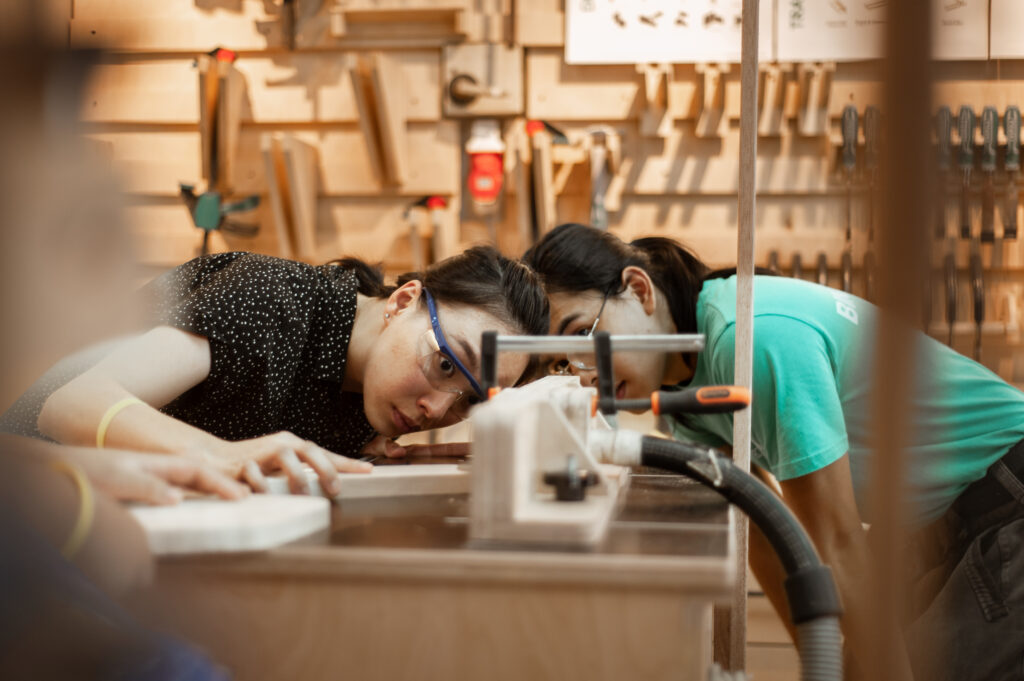Teens and young adults working at the benches in the KitaBina shop